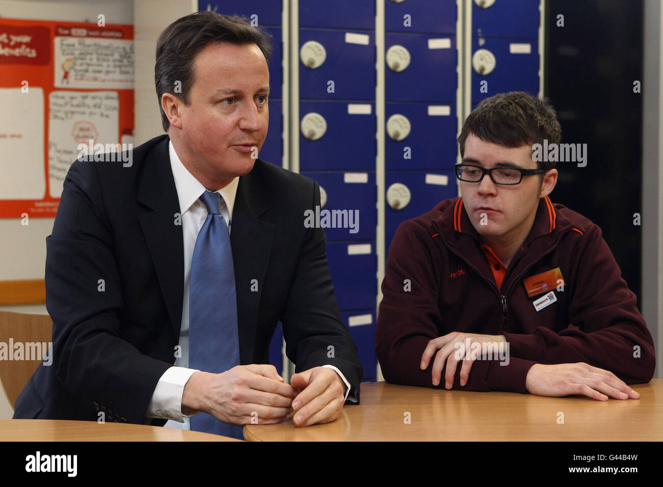 Il primo ministro David Cameron parla con il membro dello staff James Dowling durante una visita ad una filiale del supermercato Sainsbury a Londra prima di tenere un discorso sulla proposta di legge sulla riforma del benessere. Foto Stock