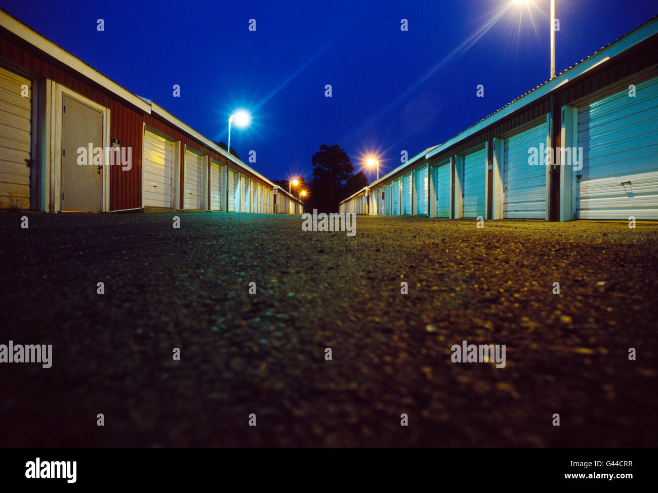 Vista notturna di garage noleggio come unità di archiviazione allineate in una fila Foto Stock