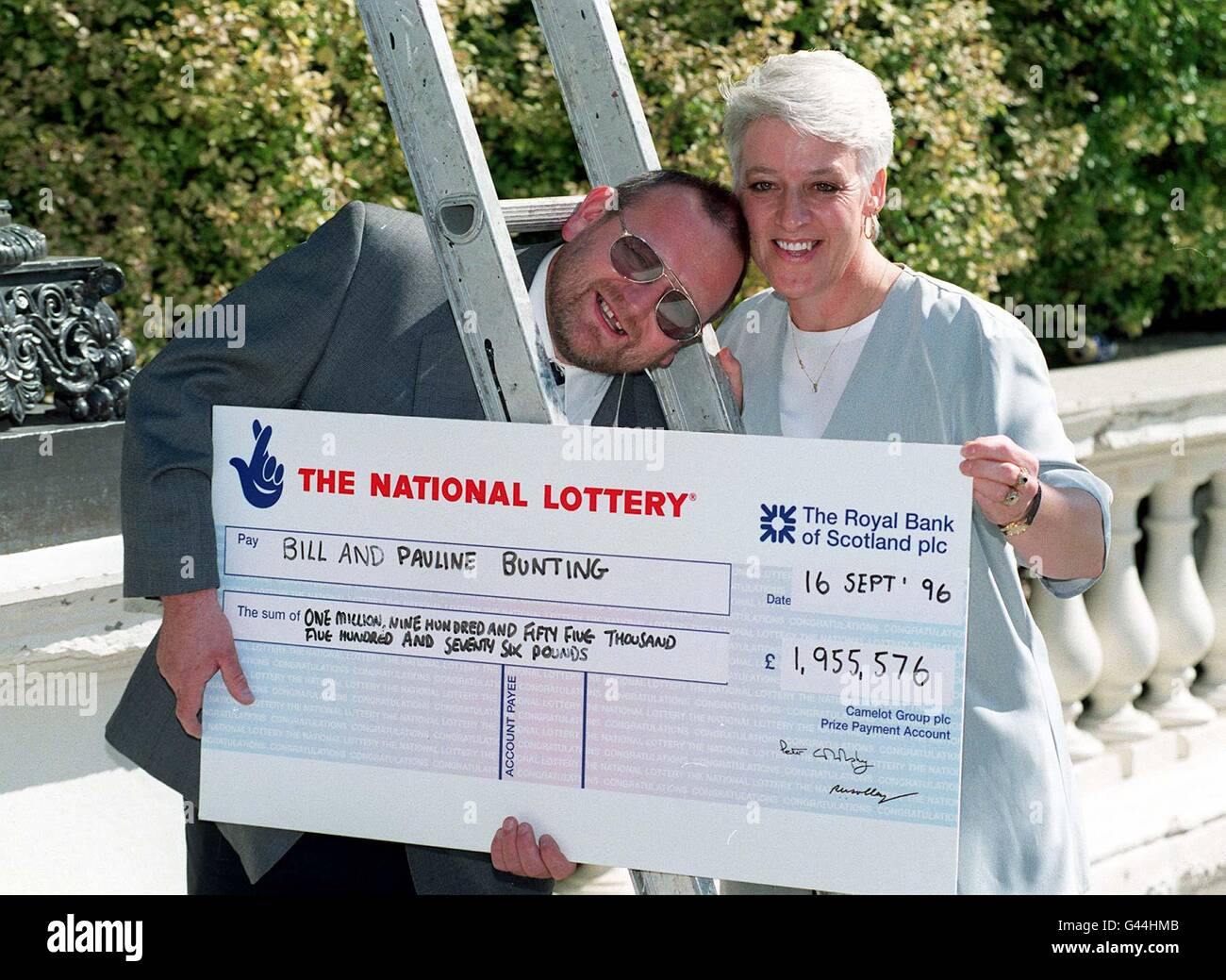 Bill e Pauline Bunting di King's Lynn, Norfolk trovare fortuna, così come un assegno molto grande, sotto una scala mentre celebrano la loro vittoria della Lotteria Nazionale di quasi 2 milioni ad una chiamata stampa questa mattina (Lunedi). Il sig. Bunting ha fatto scegliere i suoi numeri dal proprio sistema Lucky DIP di Camelot e hanno in programma di completare la ristrutturazione della loro casa e di acquistare una nuova auto, con forse un viaggio da sogno in un getto di forza aerea Tornado gettato dentro! Di John Stillwell/PA. Foto Stock