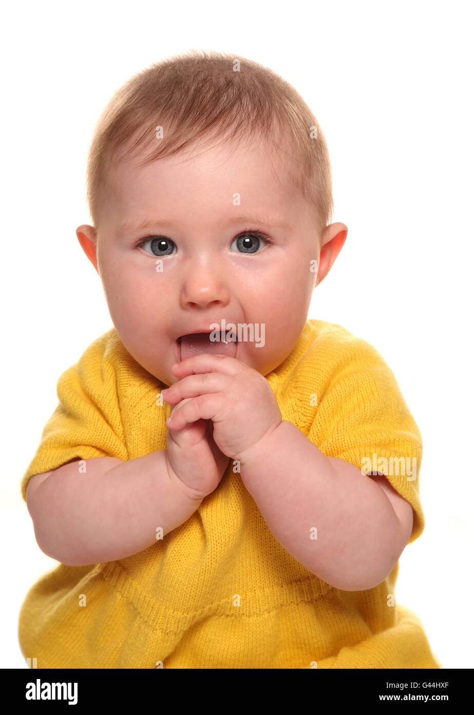 Baby girl mettendo le mani in bocca intaglio Foto Stock