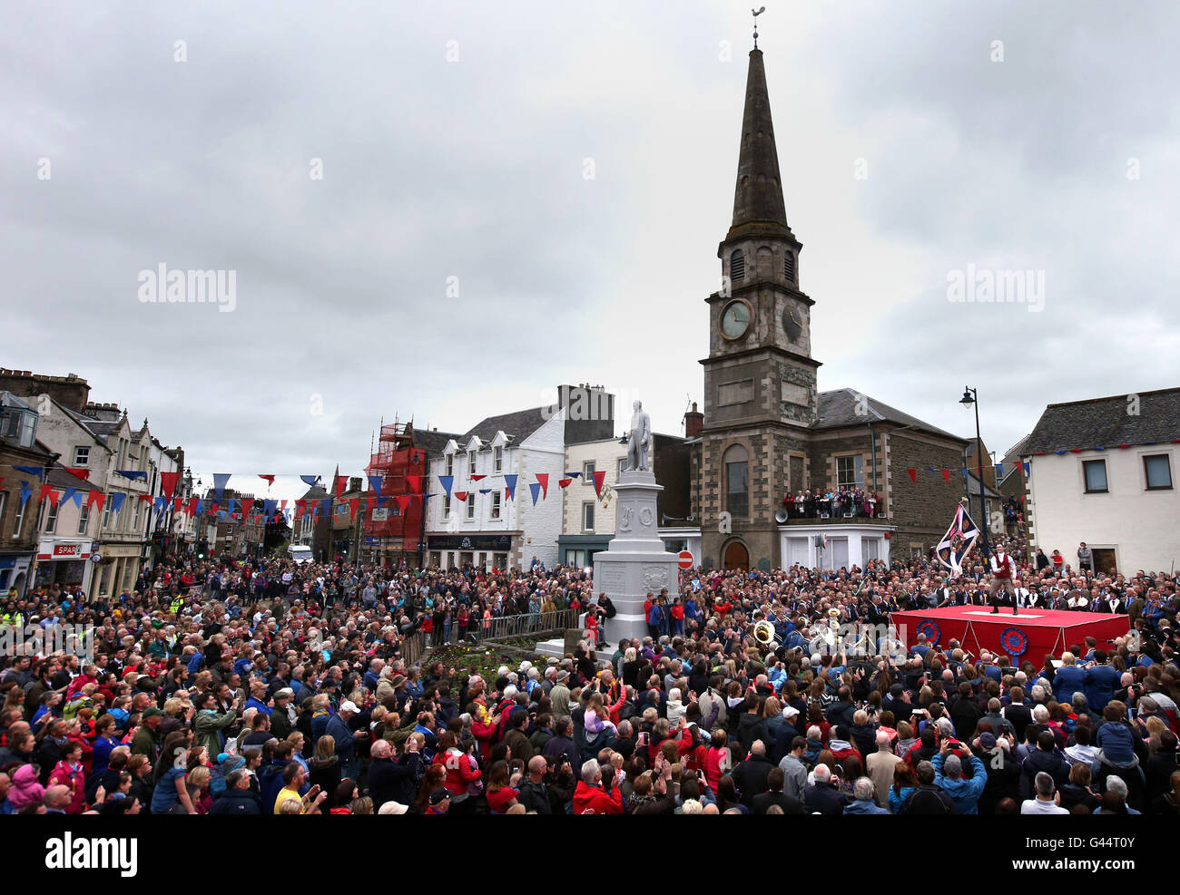 Royal Alfiere Rory J. monaci onde i burgh bandiera durante una cerimonia in Selkirk mercato del luogo durante il Selkirk Equitazione comune, una secolare tradizione nel royal burgh in Scottish Borders. Foto Stock
