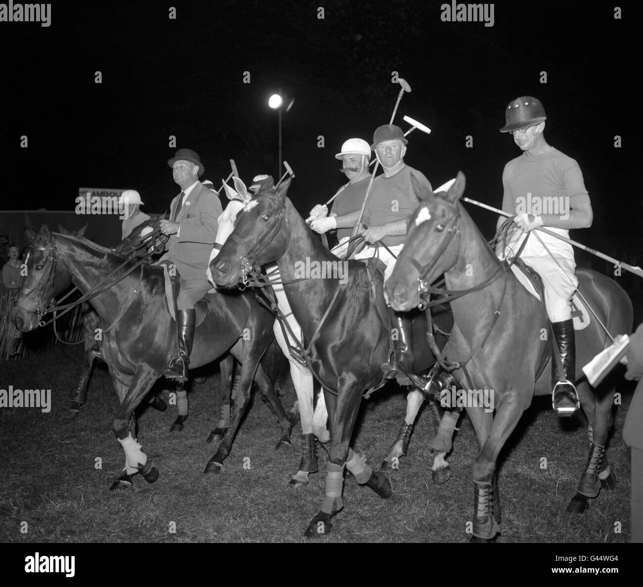 Il Duca di Edimburgo (a destra), il comico Jimmy Edwards (2° a sinistra) e Billy Walsh (al centro) si esibiscono per la loro comica partita di polo contro la squadra di Ascot sotto i riflettori nella sessione serale del Royal Windsor Horse Show al Castello di Windsor. Foto Stock