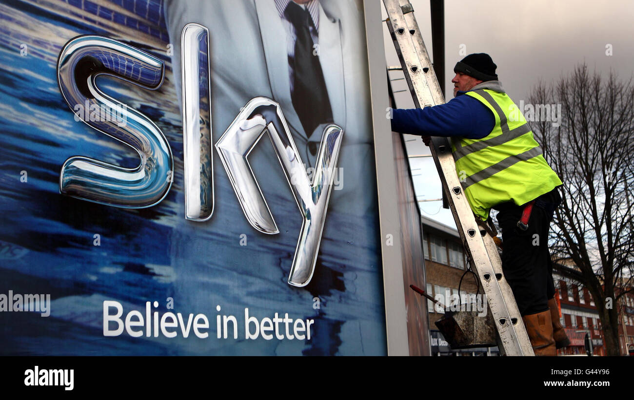 BSkyB OPA. Un lavoratore eretta un poster Sky TV a Birmingham. Foto Stock