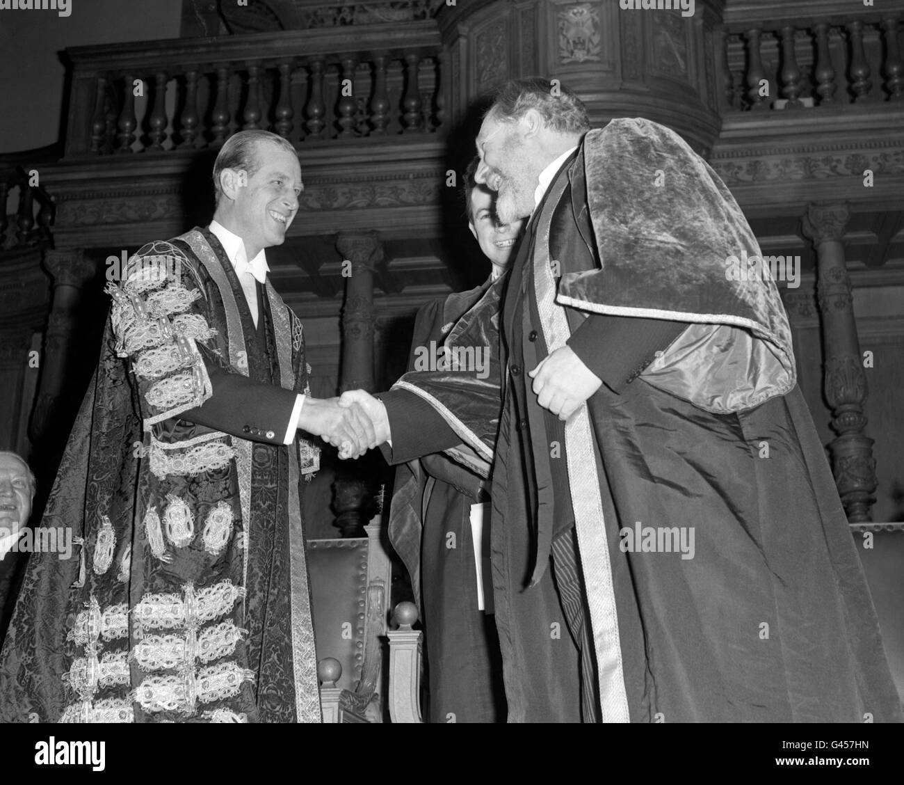 Il Duca di Edimburgo, partito, indossando gli abiti del Cancelliere dell'Università di Edimburgo, scuotendo le mani con l'attore Dr. James Robertson Justice, quando il Dr. Justice fu installato come Rettore dell'Università di Edimburgo. Foto Stock