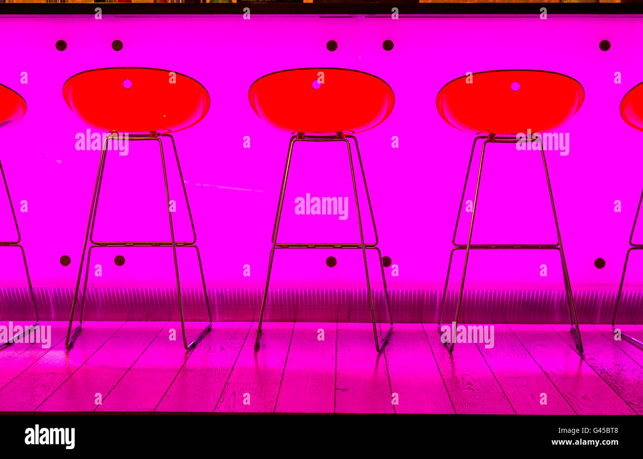 Bar, ristorante, sgabelli da bar nella parte anteriore di un colore rosa acceso banco bar, Foto Stock