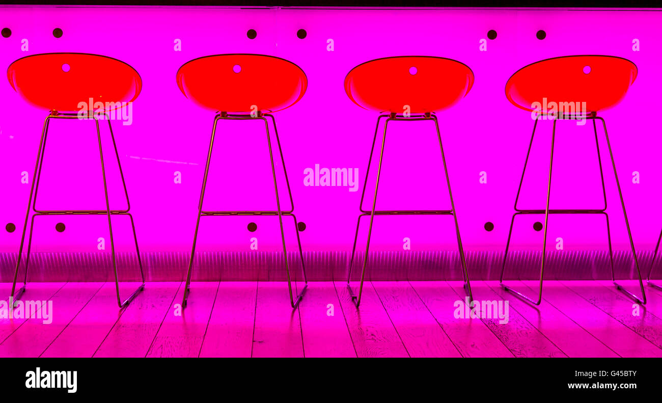 Bar, ristorante, sgabelli da bar nella parte anteriore di un colore rosa acceso banco bar, Foto Stock