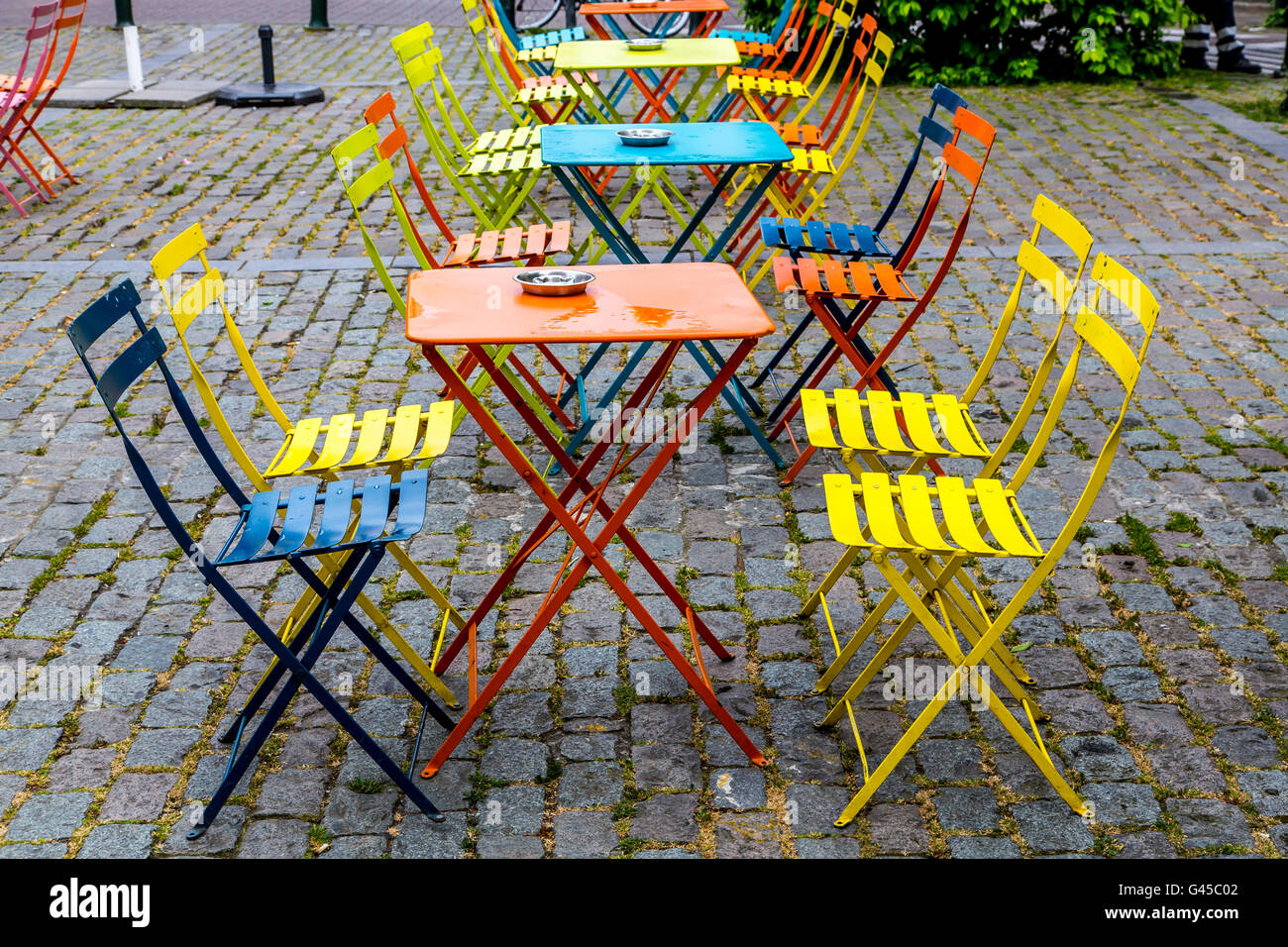 Colorati tavoli e sedie, vuoto, in una piazza di Bruxelles, Foto Stock