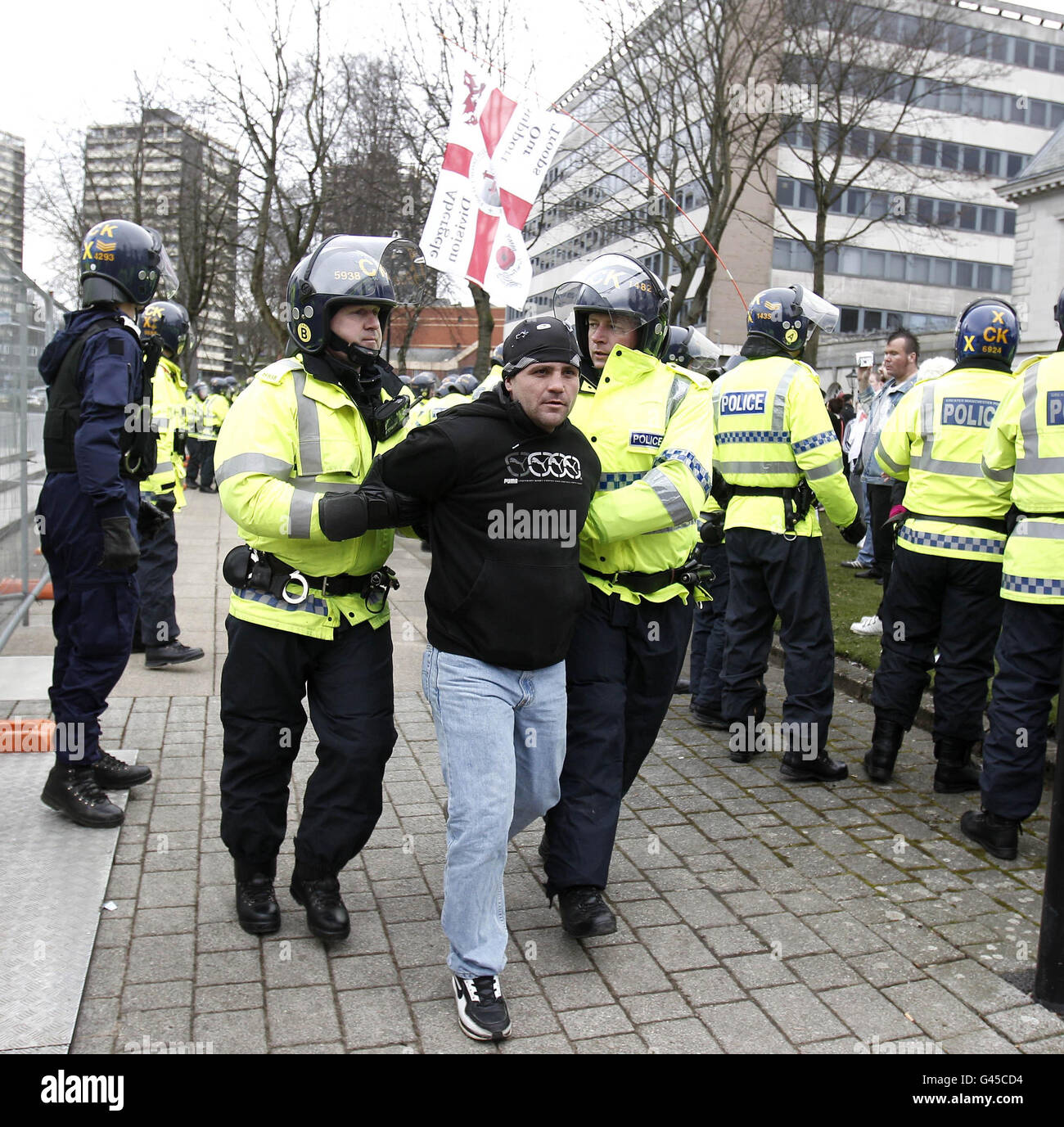 Un membro della Defense League inglese con la polizia durante una protesta in scena fuori dal Municipio di Rochdale oggi. Foto Stock