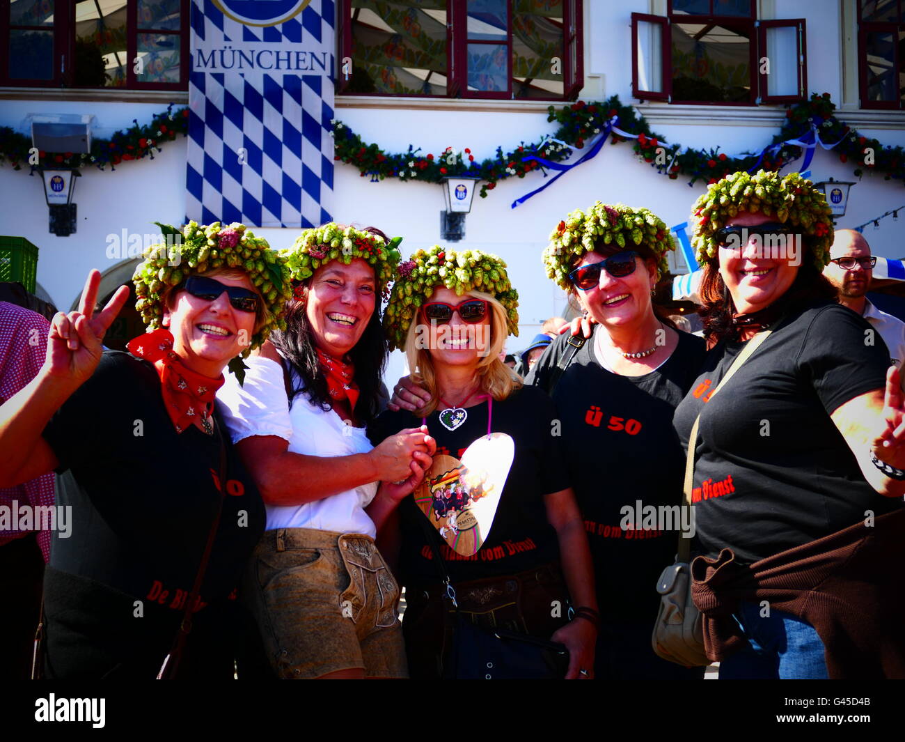 Europa Germania tedesco Oktoberfest Monaco di Baviera - Festa della Birra 2015. Un gruppo di oltre cinquanta indossando il luppolo ad anello sulla loro testa, posa per phot Foto Stock