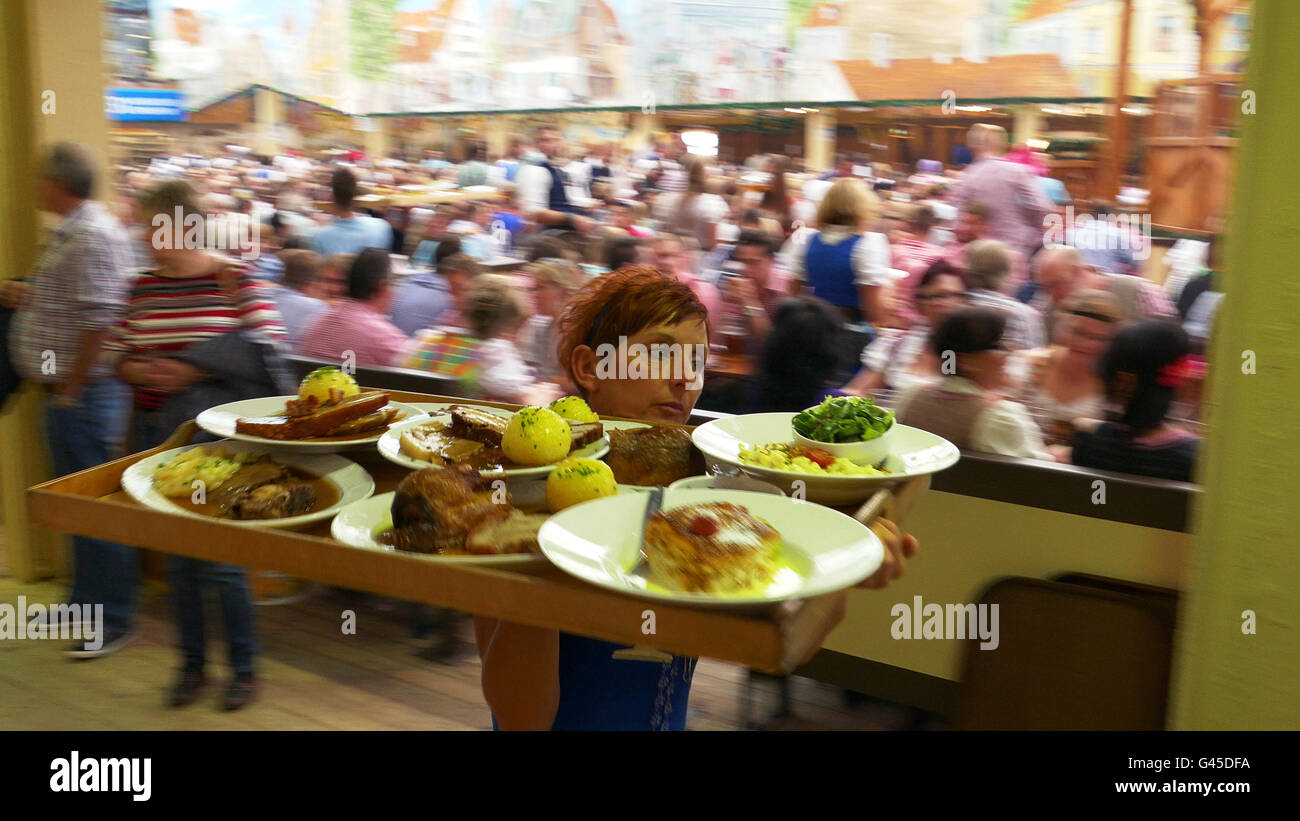 Europa Germania tedesco Oktoberfest Monaco di Baviera - Festa della Birra cameriera con pollo arrosto. Dal Video DE23248 Foto Stock