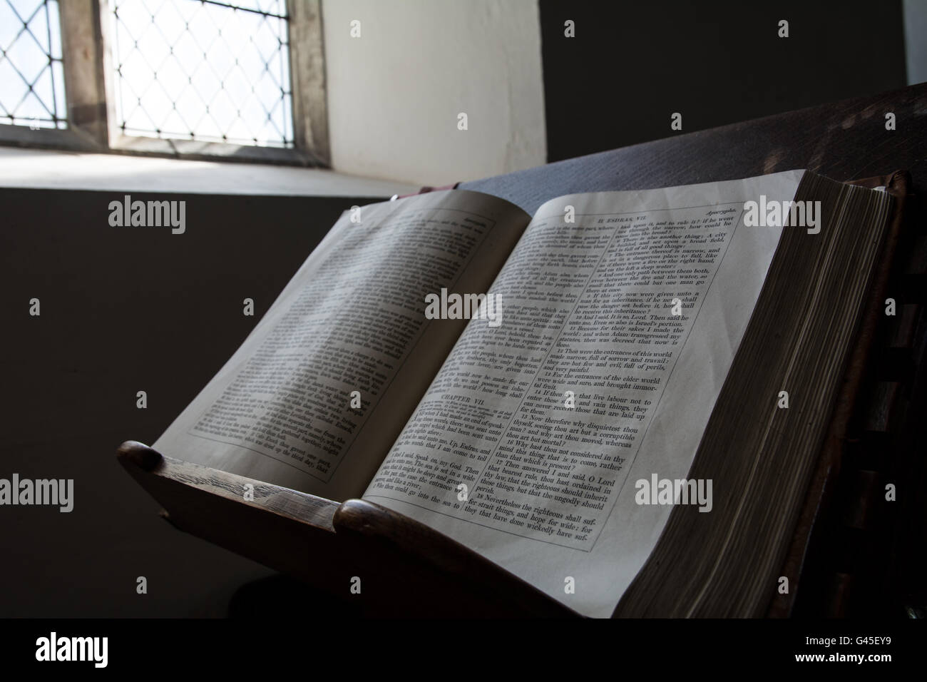 Una molto vecchia bibbia ai bagni di sole dalla finestra in una chiesa. Foto Stock