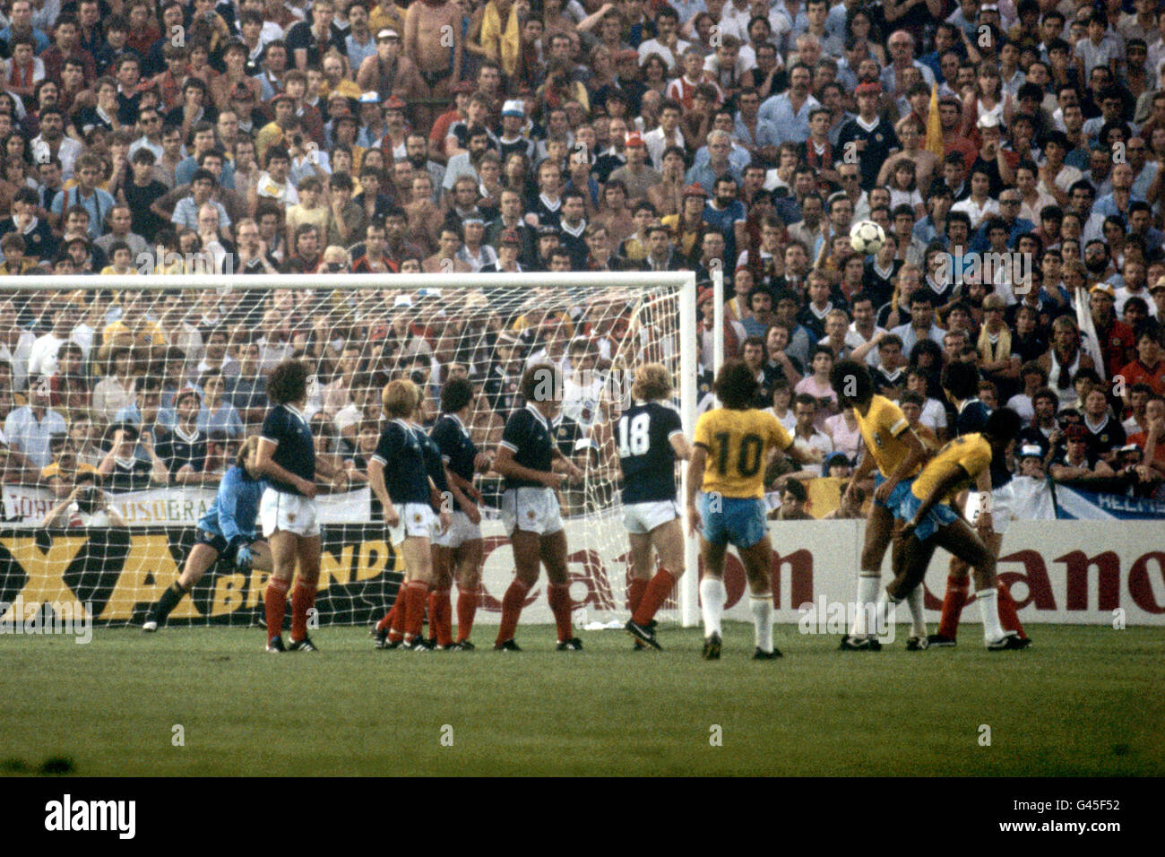 Calcio - Coppa del mondo FIFA Spagna 1982 - Gruppo sei - Brasile / Scozia - Benito Villamarin Stadium, Siviglia. Zico del Brasile (10) guarda come il suo calcio libero vola nell'angolo superiore del gol della Scozia. Foto Stock