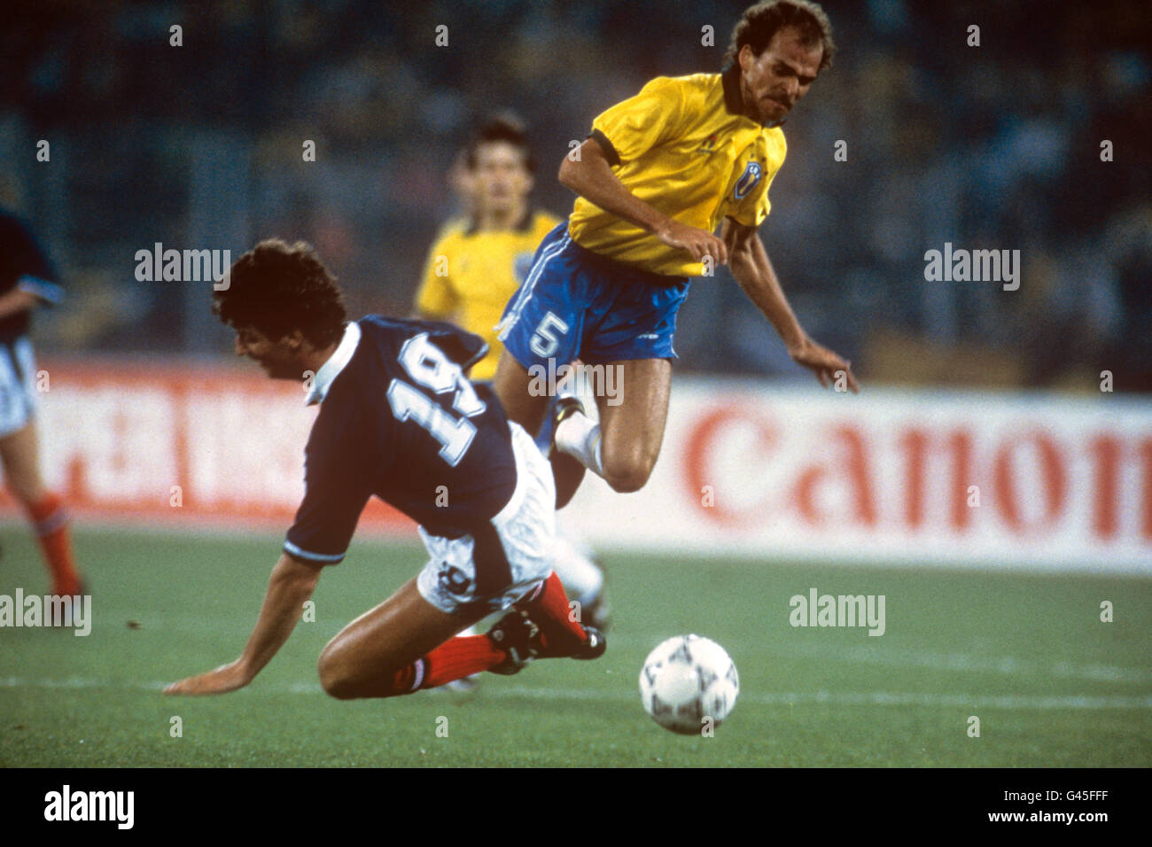 Calcio - Coppa del mondo FIFA Italia 90 - Gruppo C - Brasile / Scozia - Stadio delle Alpi, Torino. David McPherson della Scozia manda Alemao del Brasile che vola da un'attrezzatura. Foto Stock