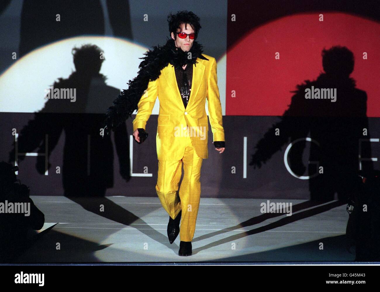 Un modello indossa un abito giallo brillante con nero a contrasto Feather boa come parte del debutto di stasera Tommy Hilfiger Spettacolo a Londra Fashion week.PHOTO DI NEIL MUNNS/PA Foto Stock