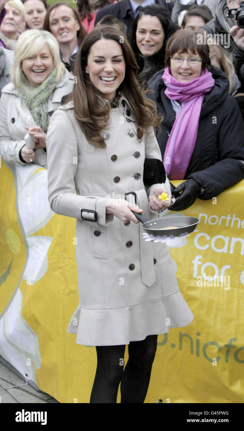 Kate Middleton sorride mentre salta una frittella in una mostra del Northern Ireland Cancer Fund for Children al di fuori del municipio di Belfast durante la loro visita in Irlanda del Nord. Foto Stock