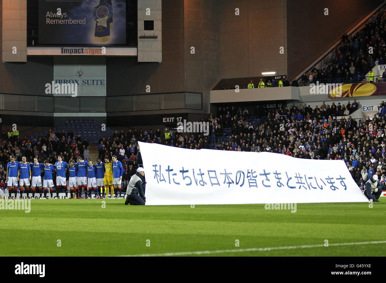 I giocatori di Rangers osservano un minuto di silenzio per le vittime del disastro giapponese durante la partita UEFA Europa League allo Ibrox Stadium di Glasgow. Foto Stock