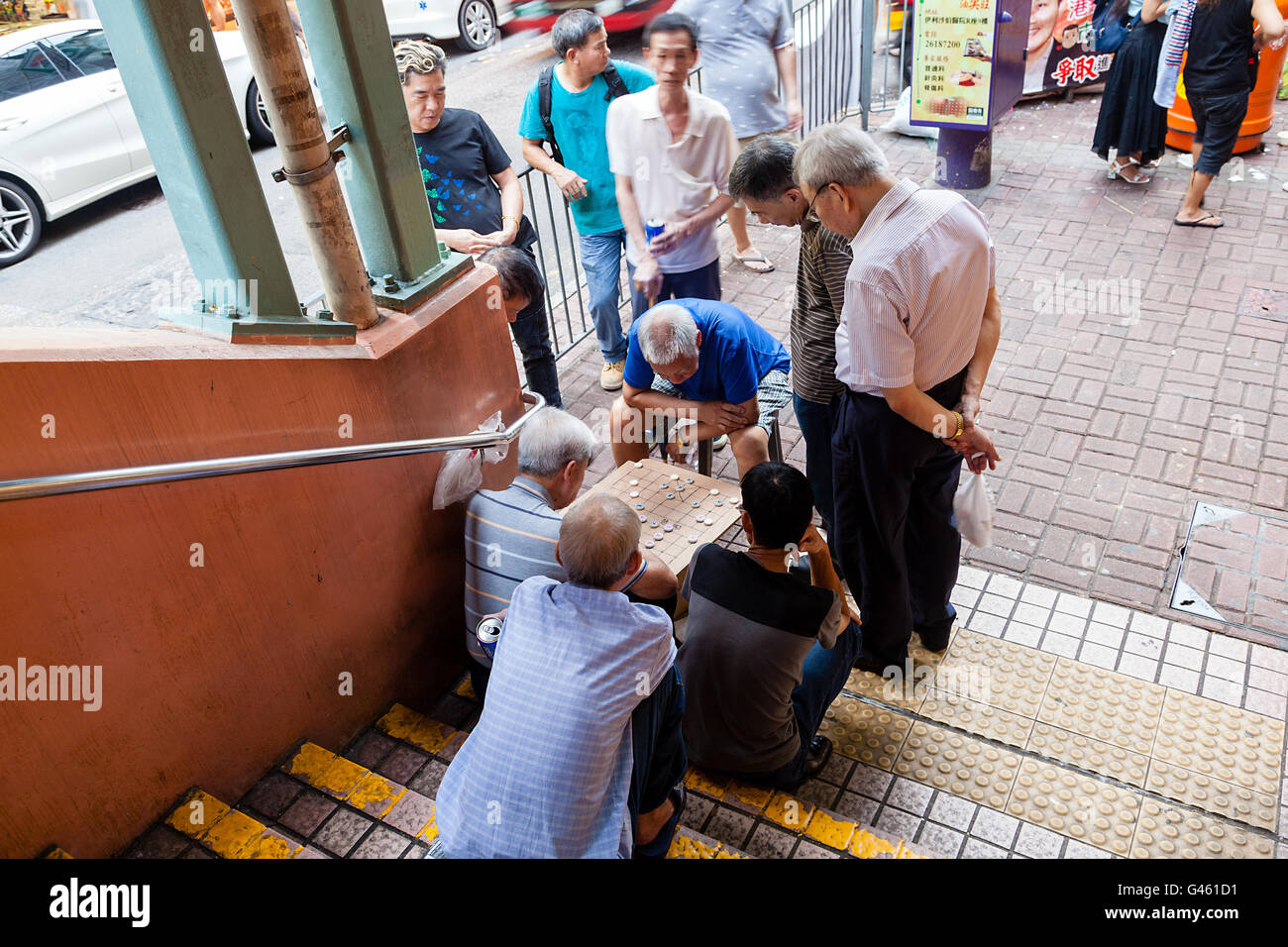 Hong Kong - Luglio 26, 2015: un gruppo di uomini anziani si impegnano in un gioco di scacchi cinesi sull'angolo di una strada di Fa Yuen Street. Foto Stock