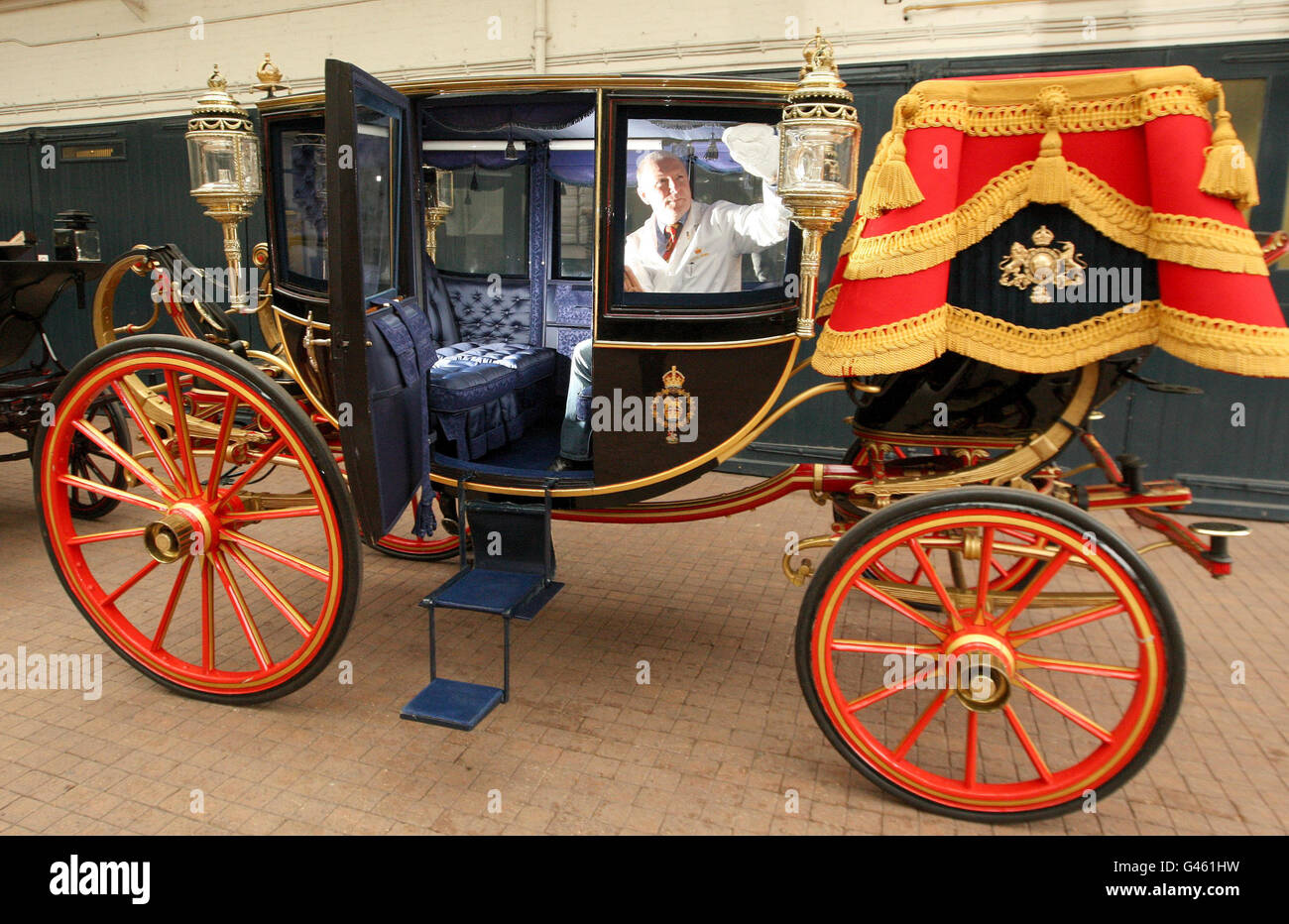 Carriage Restorer Dave Evans pulisce la Glass Coach presso i Royal Mews nel centro di Londra. Foto Stock