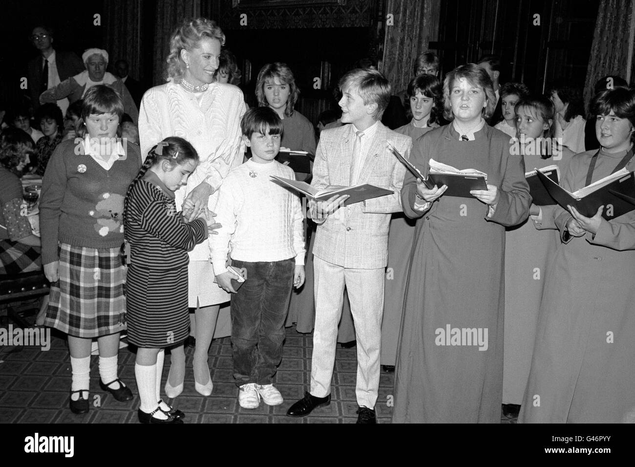 La principessa Michael of Kent canta 'Silent Night' con la stella corale adolescente Aled Jones (al centro), e i membri del coro in una festa di Natale per 100 bambini ciechi e handicappati gestiti dal Royal National Institute for the Blind, presso la House of Commons, Londra. Foto Stock