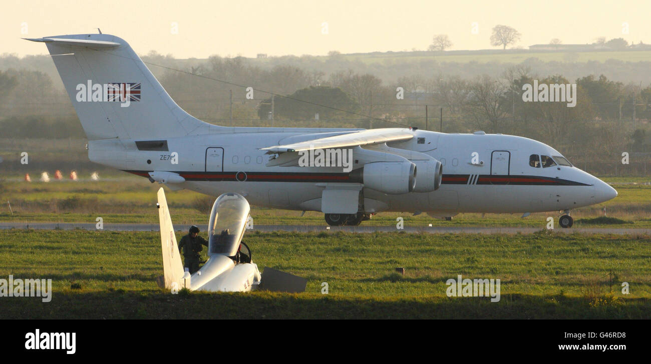 Un pilota di caccia a getto RAF Typhoon sale dal suo aereo alla base dell'Aeronautica Italiana di gioia del Colle, vicino Bari, nel sud Italia, mentre atterra un aereo passeggeri VIP RAF. Foto Stock