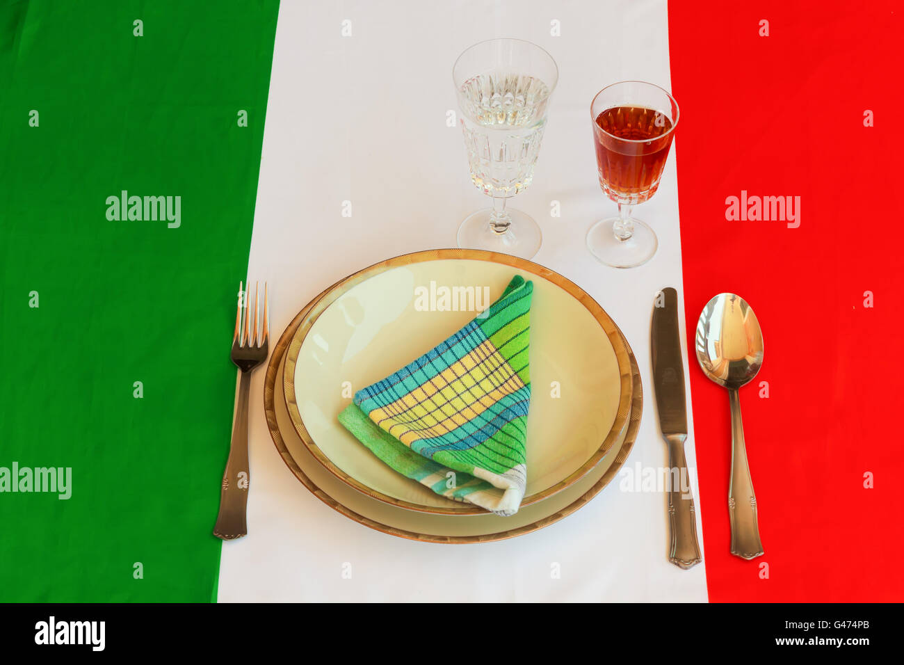 Piatti, tazze,tovagliolo e posate sono supportati sulla bandiera italiana per indicare che è la cottura di specialità italiane Foto Stock