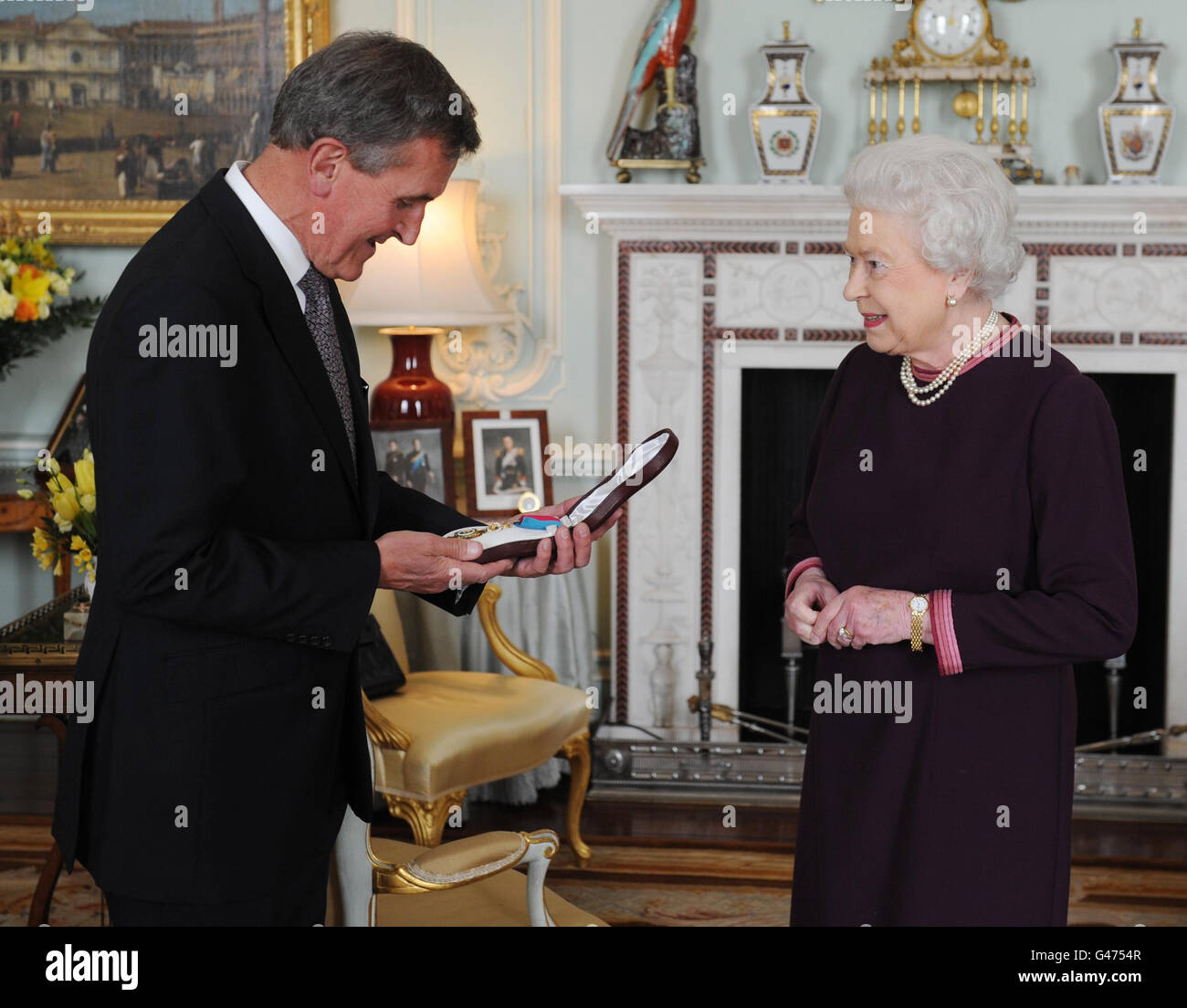 La Regina Elisabetta II presenta l'Ordine del merito a Neil MacGregor, il Direttore del British Museum di Buckingham Palace a Londra oggi. Foto Stock