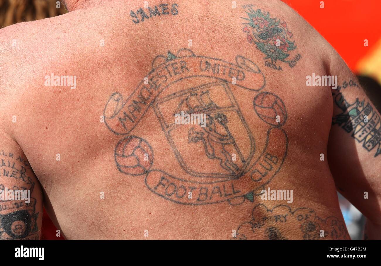 Un fan con un grande tatuaggio di cresta del Manchester United club sulla schiena Foto Stock