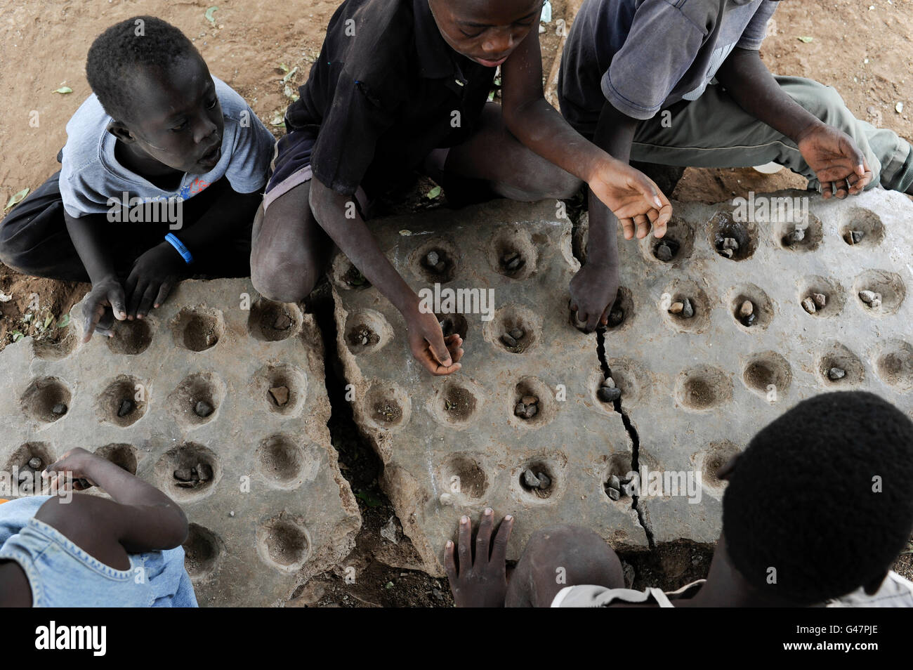 KENYA Turkana regione, campo di rifugiati di Kakuma, dove 80.000 rifugiati vivono il JESUIT REFUGEE SERVICE school , i bambini di giocare una partita su pietra Foto Stock