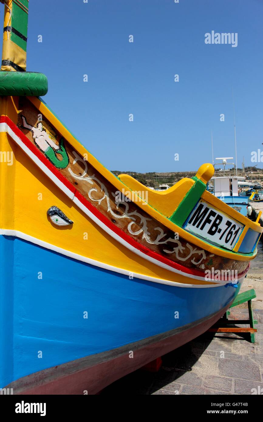 Un Maltese tradizionale barca da pesca, localmente noto come un Luzzu, ancorata nella Baia di Marsaxlokk. Foto Stock