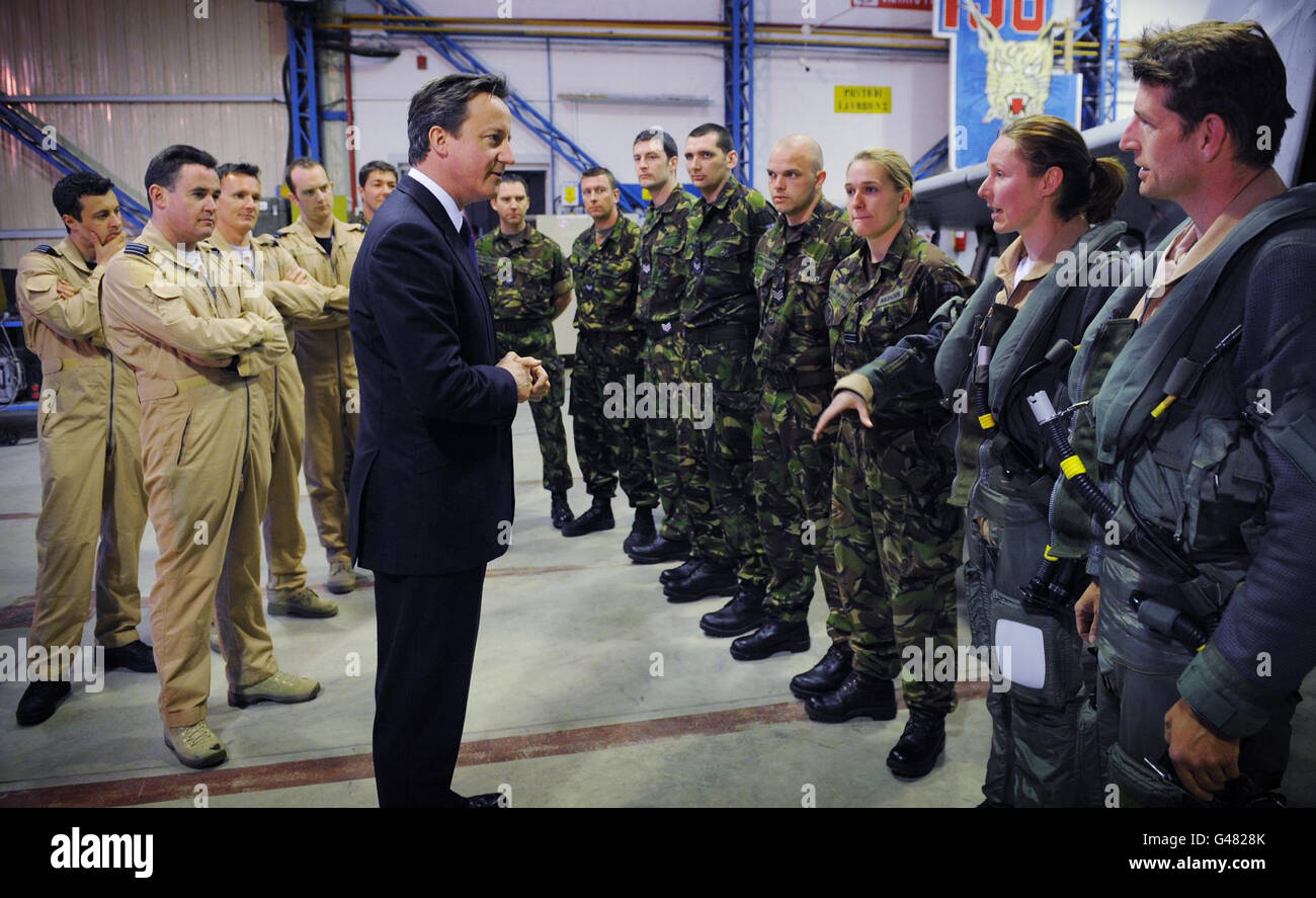 Il primo Ministro David Cameron parla con i piloti e gli equipaggi di terra a gioia del Colle, tra cui la femmina Typhoon, la tenente di volo Helen Seymour (seconda a destra) che ha volato i tifoni in azione sulla Libia, durante una visita a sorpresa alla base aerea italiana nel sud Italia. Foto Stock