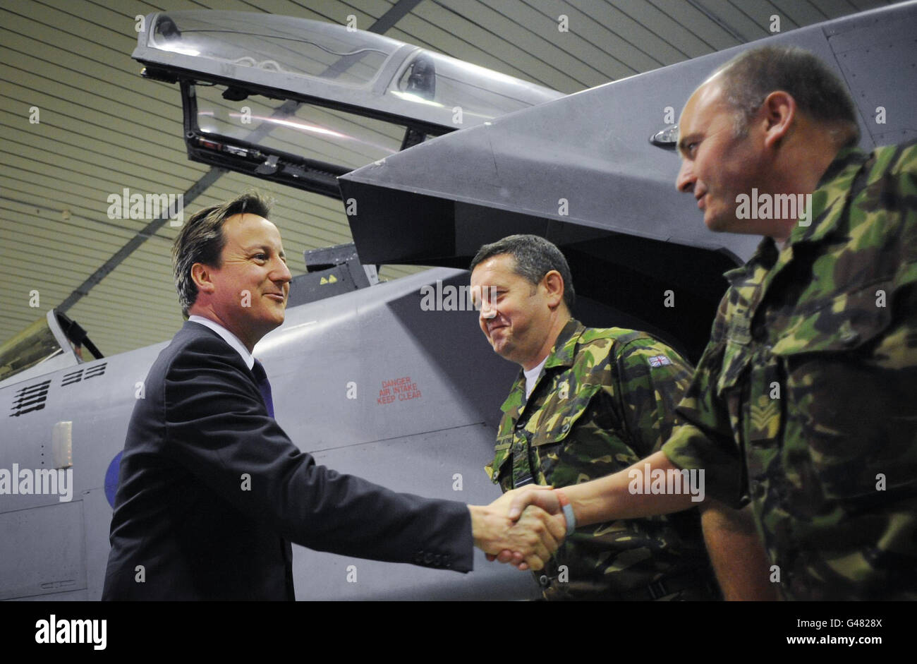 Il primo Ministro David Cameron parla con l'equipaggio di terra RAF e i piloti a gioia del Colle, durante una visita a sorpresa alla base aerea italiana nel sud Italia. Foto Stock