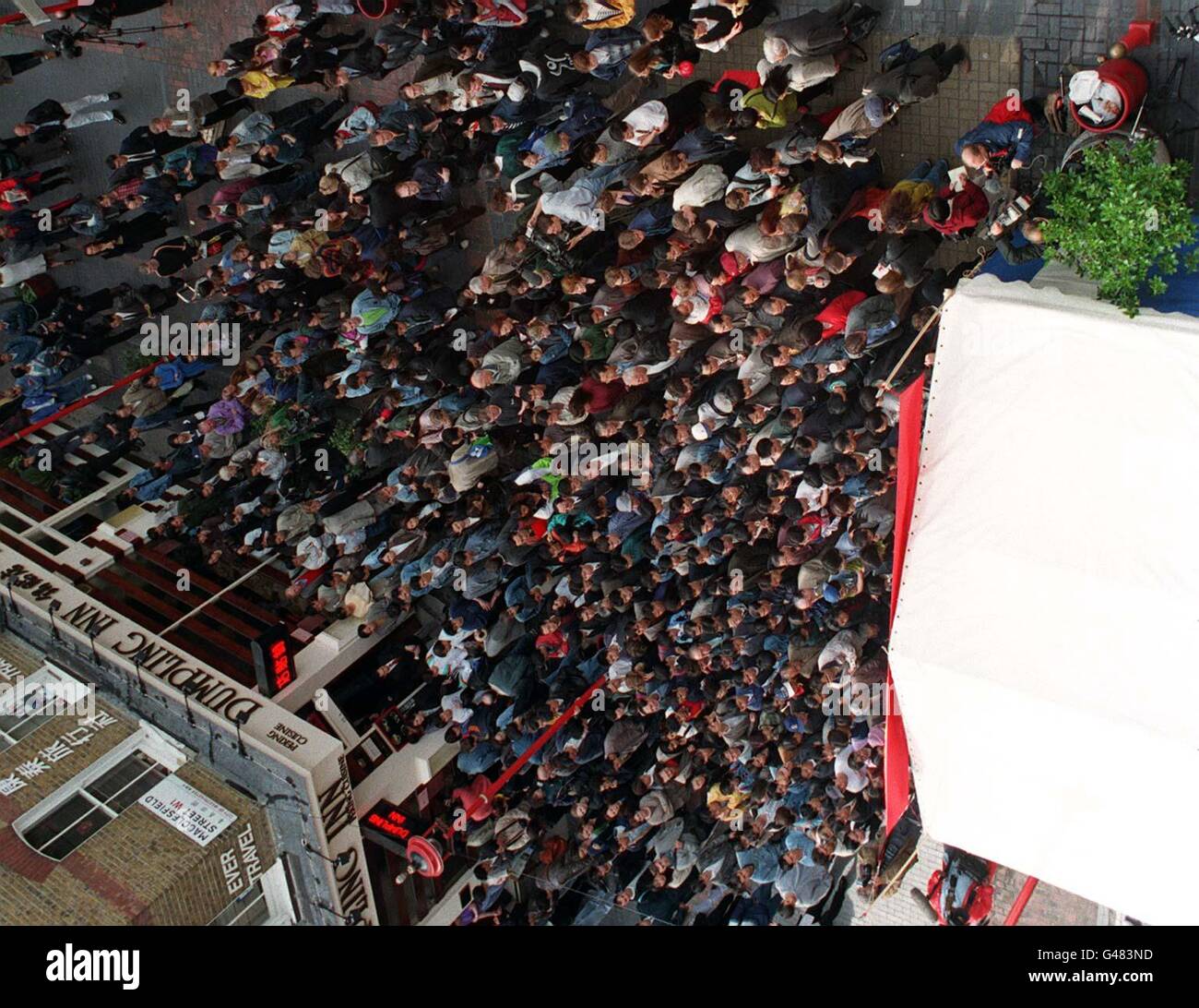 Le folle si riuniscono di fronte a un grande schermo televisivo a Londra China Town oggi (lunedì) per guardare il momento storico mentre la Gran Bretagna ha ufficialmente consegnato Hong Kong ai cinesi. Guarda la storia di PA. Foto di ben Curtis/PA. Foto Stock