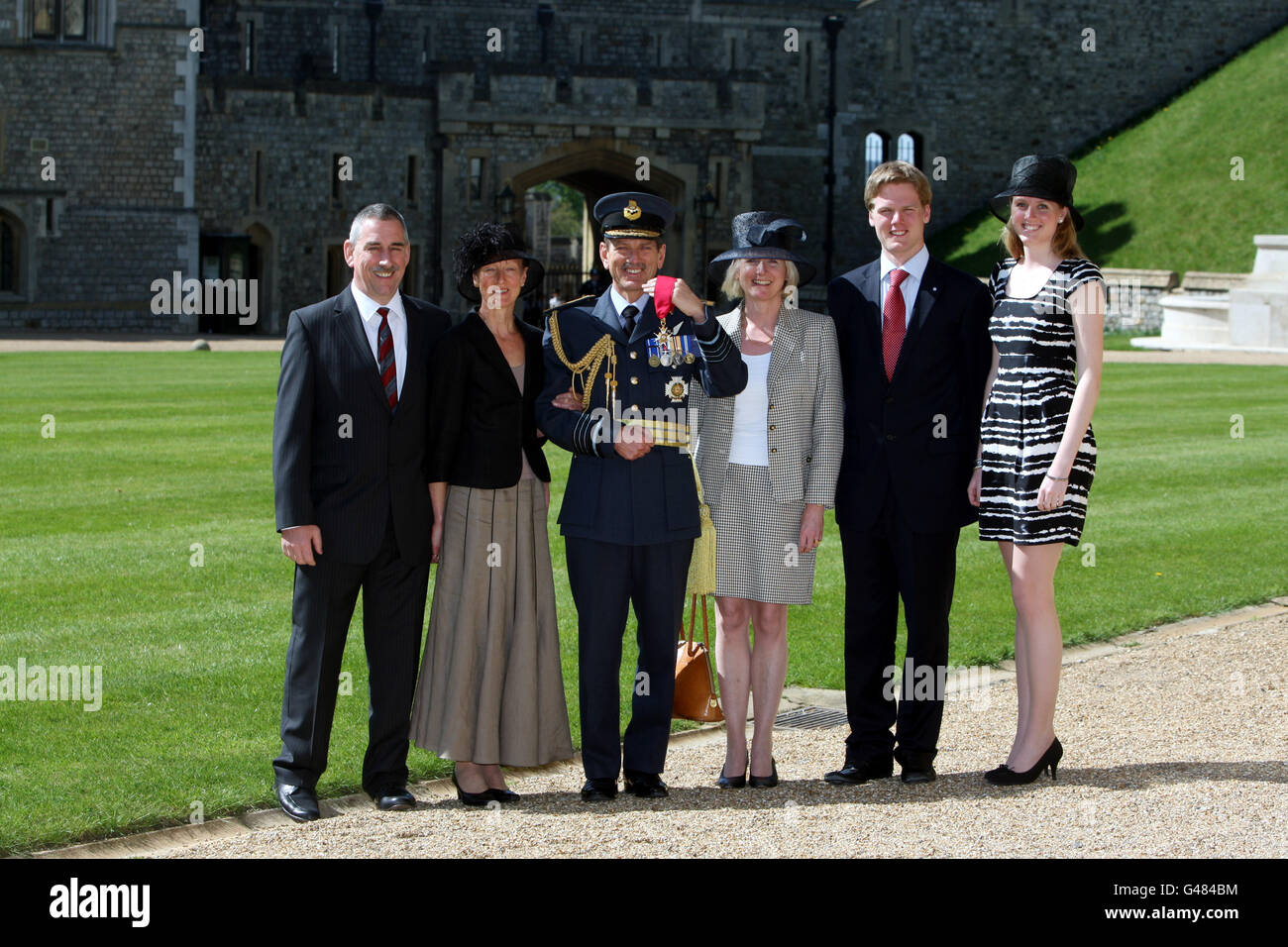 Il maresciallo capo dell'aria Sir Simon Bryant con (da sinistra) Richard Meller e Helen Meller, sua moglie Helen, il figlio Benjamin e la figlia Alexandra fuori dal castello di Windsor dopo essere stato nominato comandante cavaliere dell'Ordine del bagno dalla regina Elisabetta II dopo una cerimonia di investitura. Foto Stock