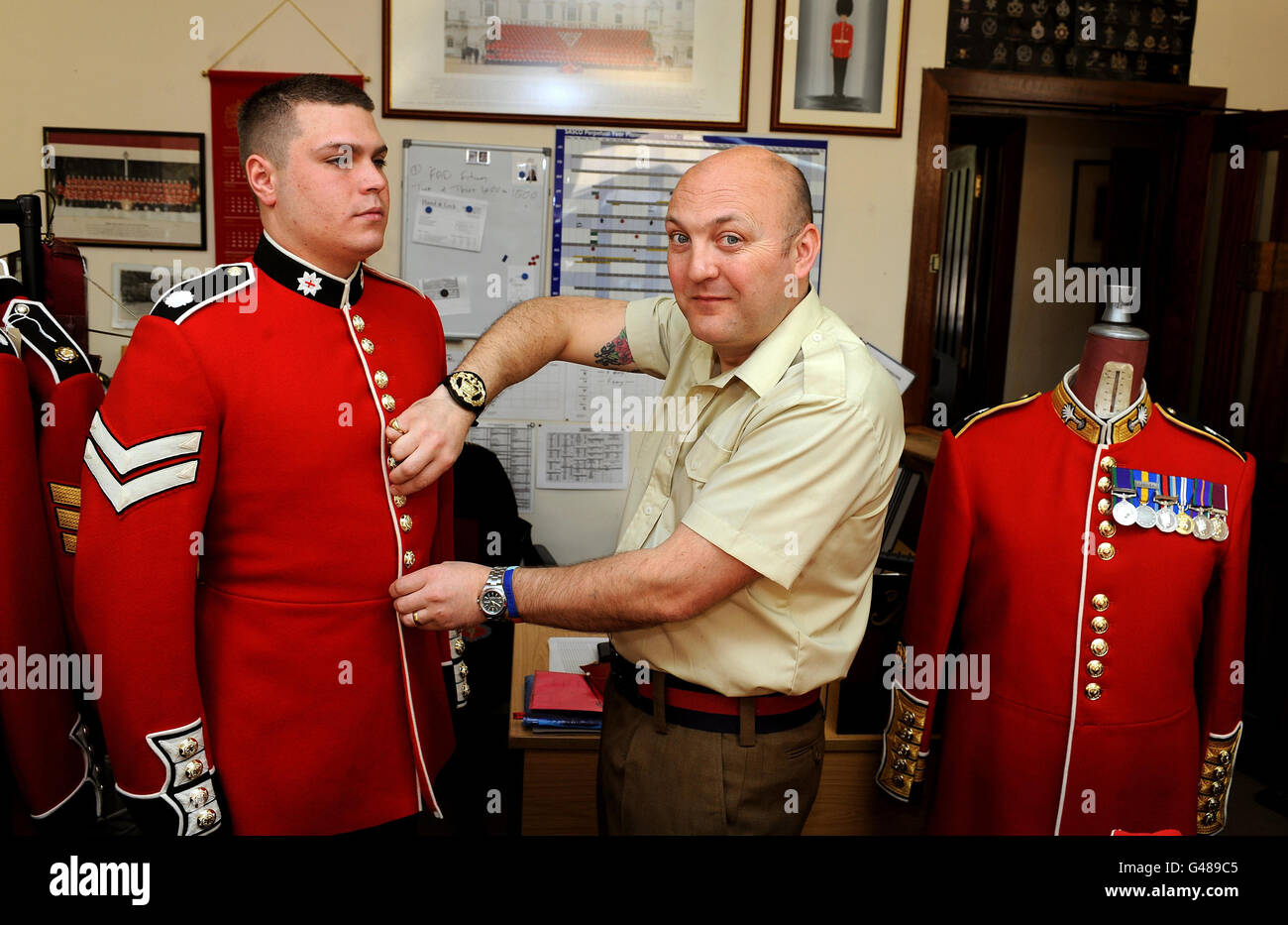 Senior Master Tailor Steve Shield (a destra) taglia Martin Hughes delle guardie Coldsteam, mentre regola la tunica in preparazione al matrimonio reale del Principe William e Kate Middleton, a Wellington Barracks Londra. Foto Stock