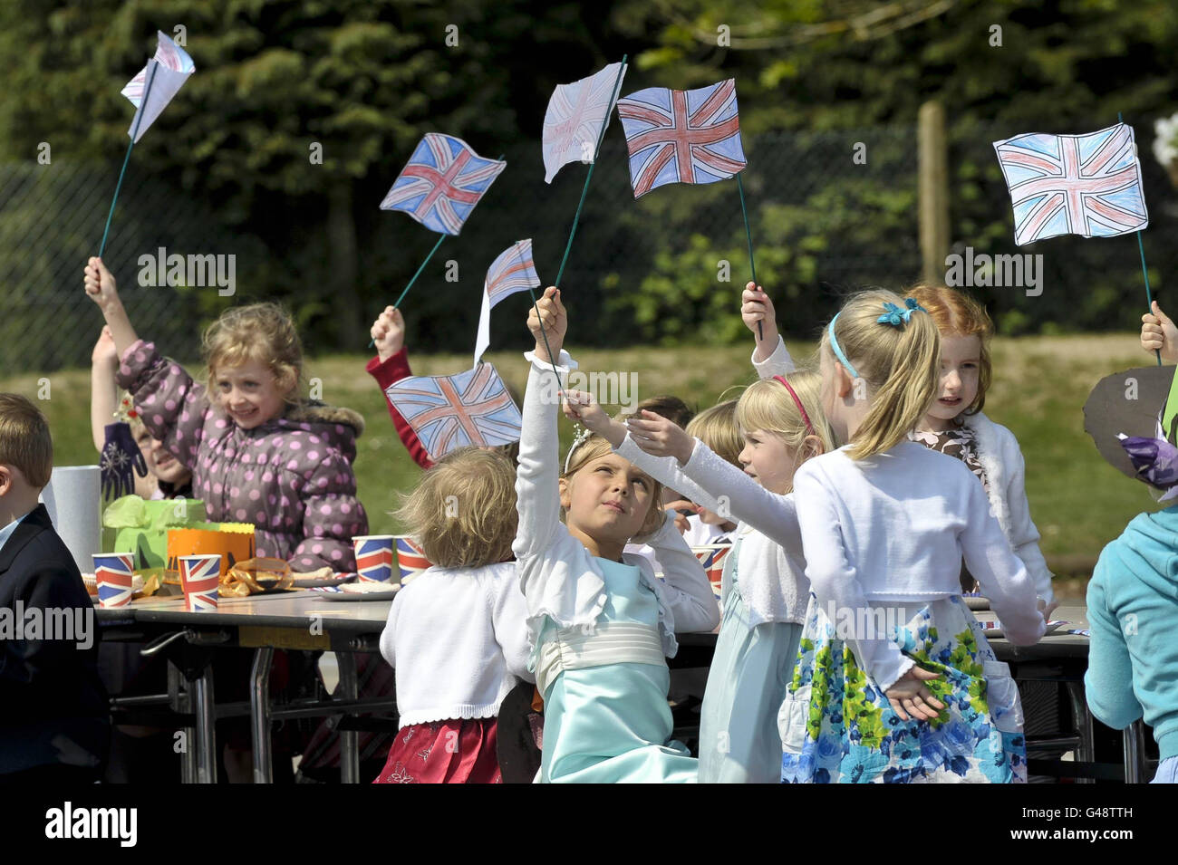I bambini volano le loro bandiere unioniche fatte a mano alla Bucklebury Church of England Primary School Royal Wedding party nel parco giochi della scuola. Foto Stock