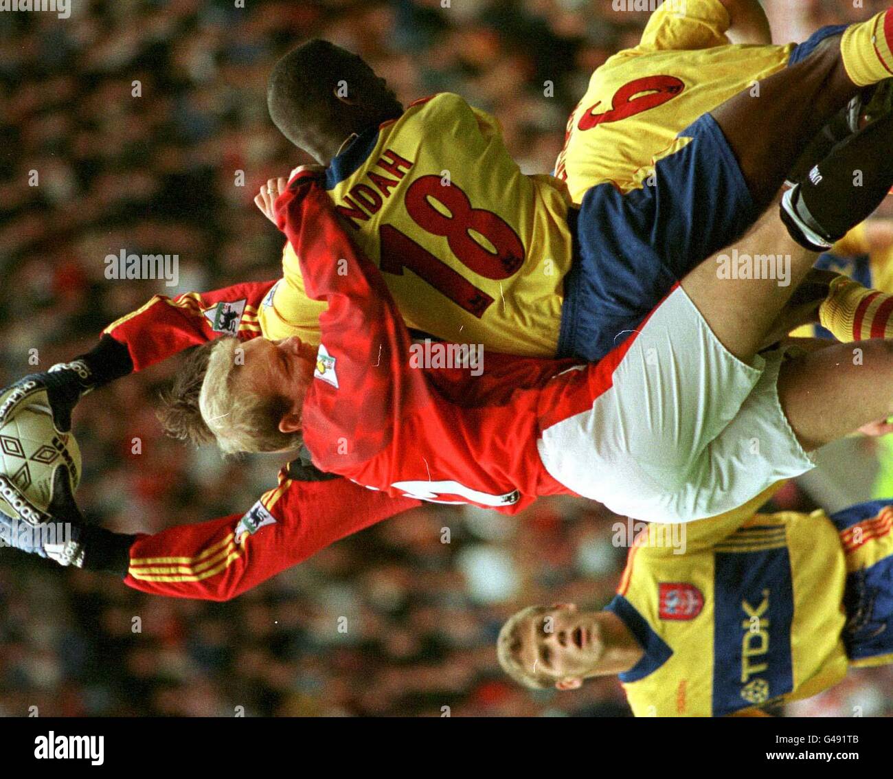 Henning Berg di Manchester United e George Ndah di Crystal Palace si scontrano con Kevin Miller, portiere di Crystal Palace, che salva la palla durante la partita di premiership di oggi (sabato) a Old Trafford. Foto di Paul Barker/PA Foto Stock