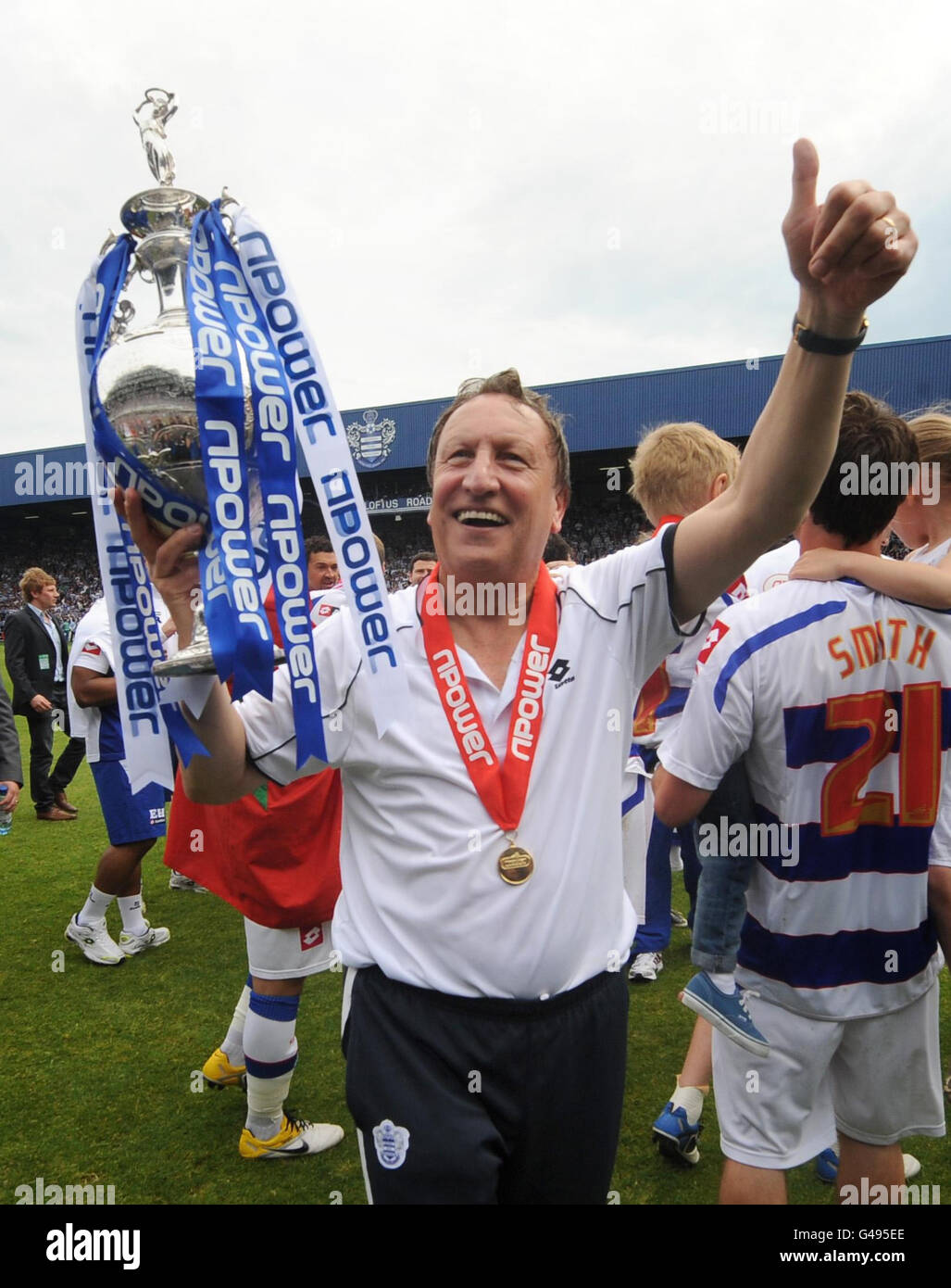 Neil Warnock porta il trofeo mentre i giocatori del QPR festeggiano dopo aver ricevuto il Championship Trophy successivo durante la partita del campionato Npower Football League a Loftus Road, Londra. Foto Stock