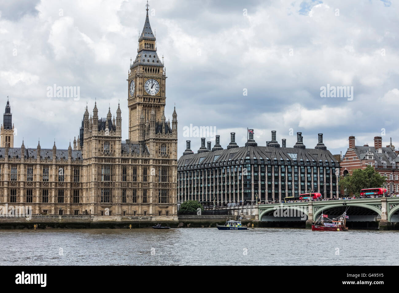 Barche da pesca sul fiume Tamigi di fronte al Palazzo del Parlamento e il Big Ben e autobus rossi a Westminster Bridge Foto Stock