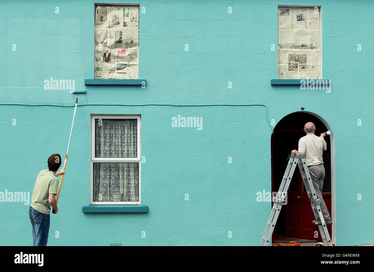 La gente del posto dipinge un edificio a Moneygall, Co Offaly, mentre Obama-Fever sta spazzando il villaggio con la gente del posto che ripara i pavimenti e dipingendo le case prima dell'arrivo del presidente Barack Obama più tardi questo mese. Foto Stock