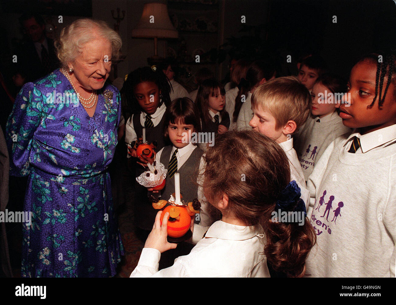 La Regina Madre, patrona della Children's Society, circondata da bambini della St Matthew's Church of England Primary School, a Chapel Allerton, Leeds, alla Clarence House di Londra oggi (martedì), dove cantavano i canti natalizi per conto della Children's Society. Foto di John Stillwell. Foto Stock