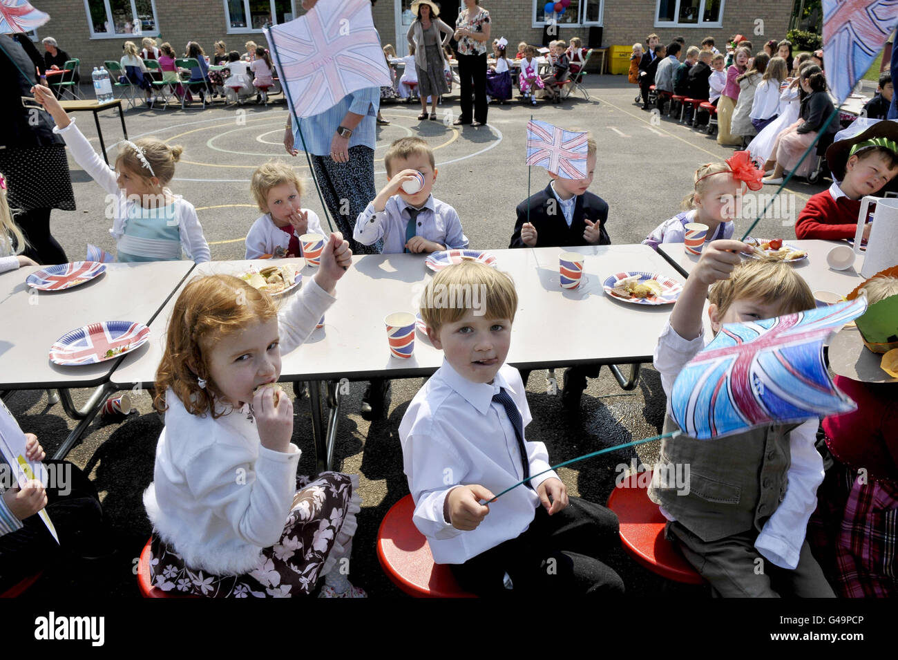 I bambini volano le loro bandiere unioniche fatte a mano alla Bucklebury Church of England Primary School Royal Wedding party nel parco giochi della scuola. Foto Stock