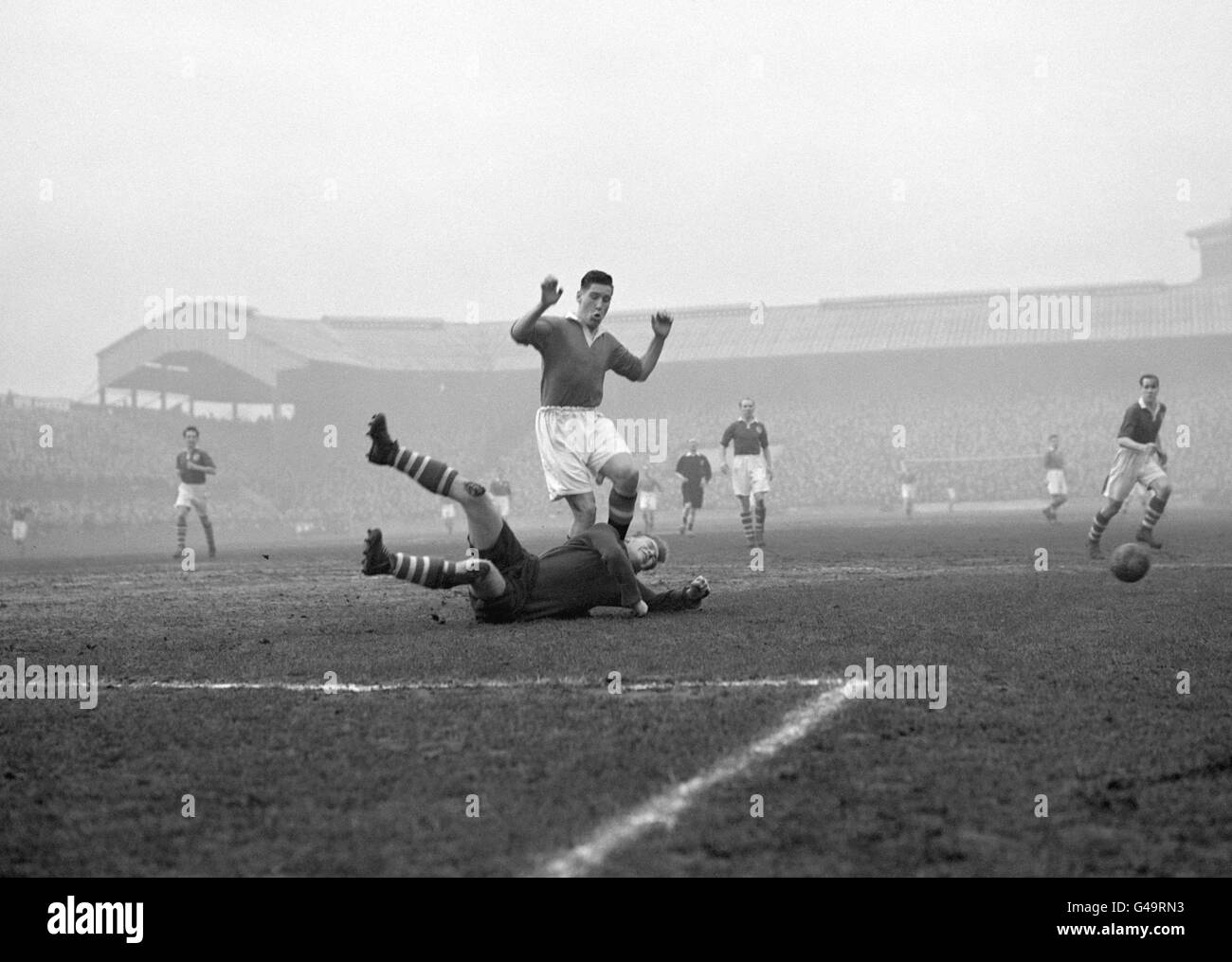 Edward 'Eddie' Lewis, centro-avanti di 17 anni di Manchester United, salta su Malcolm Finlayson, il portiere della Millwall, nella fa Cup terzo round craving al Den, New Cross, Londra. Foto Stock