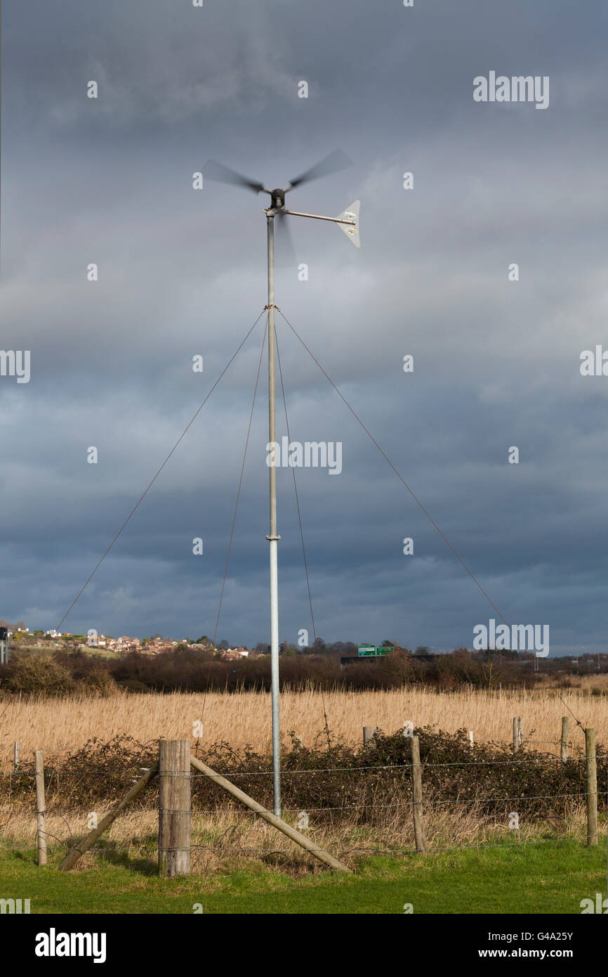 Piccolo centro rurale di vento generatore di potenza contro stormy nuvoloso cielo nuvoloso, Portsmouth, Hampshire, Inghilterra, Regno Unito, Europa Foto Stock