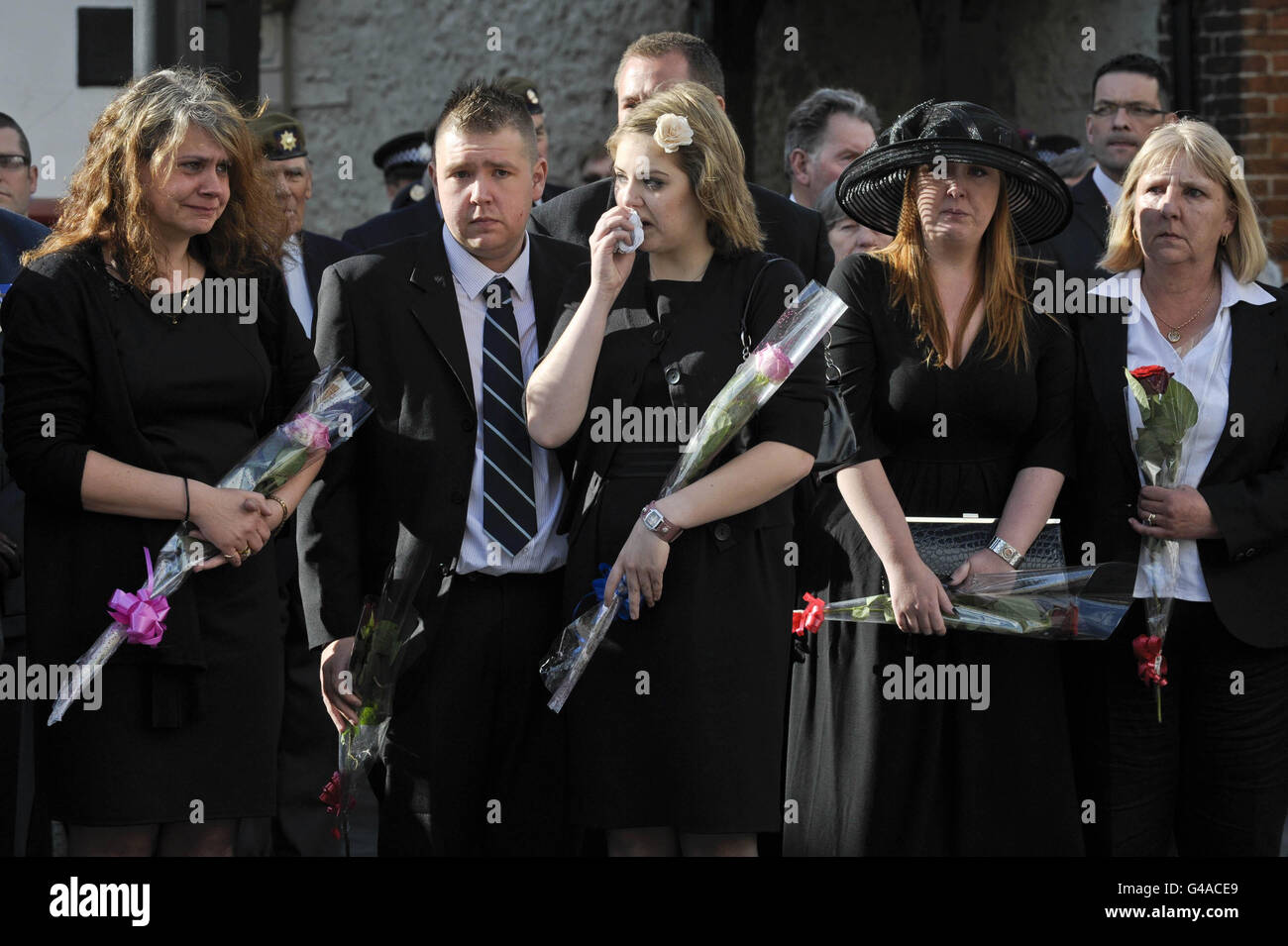 Famiglia e amici del warrant Officer Classe 2 Graham Bean, morto il 3 maggio dopo essere stato improvvisamente ammalato durante la mountain bike, reagiscono in attesa del cuore, contenente la bandiera dell'Unione coperta bara del servitore di 54 anni, Che ha servito con i volontari regimentali del 73, per arrivare sulla High Street della città Wiltshire di Wootton Bassett come corpo di Graham è rimpatriato nel Regno Unito. Foto Stock