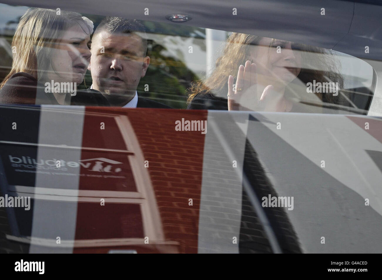 Famiglia e amici del warrant Officer Classe 2 Graham Bean, morto il 3 maggio dopo essere stato improvvisamente ammalato durante la mountain bike, reagiscono in attesa del cuore, contenente la bandiera dell'Unione coperta bara del servitore di 54 anni, Che ha servito con i volontari regimentali del 73, per arrivare sulla High Street della città Wiltshire di Wootton Bassett come corpo di Graham è rimpatriato nel Regno Unito. Foto Stock