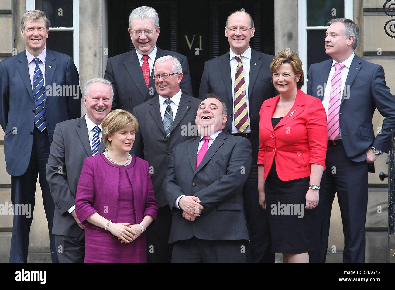 Il primo ministro scozzese Alex Salmond ride mentre si trova sui gradini di Bute House, Edimburgo, con il suo vice Nicola Sturgeon e il suo nuovo gabinetto (fila posteriore, da sinistra a destra), il segretario alla giustizia Kenny MacAskill MSP, il segretario all'istruzione Michael Russell MSP, il segretario alle finanze John Swinney, gli affari rurali Richard Lochhead MSP, (In media fila, da sinistra a destra) Segretario alle infrastrutture Alex Neil MSP, Segretario alle imprese e al governo Bruce Crawford MSP e Segretario alla Cultura Fiona Hylop. Foto Stock