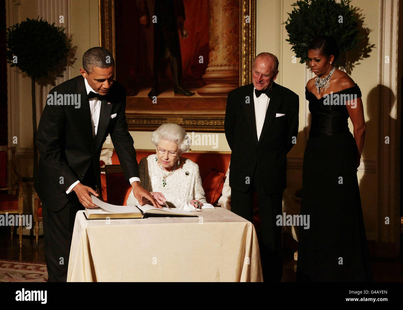 La regina Elisabetta II firma il libro degli ospiti mentre lei fa il congedo al presidente degli Stati Uniti Barack Obama e alla prima signora Michelle Obama, guardato dal duca di Edimburgo a Winfield House - la residenza dell'ambasciatore degli Stati Uniti d'America - a Regent's Park, Londra. Foto Stock