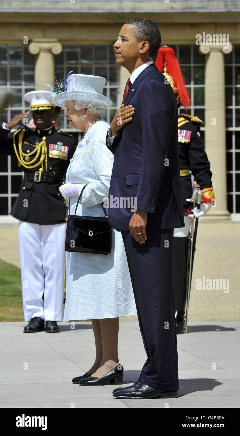 La regina Elisabetta II e il presidente degli Stati Uniti Barack Obama si levano in piedi per l'inno nazionale degli Stati Uniti nel giardino di Buckingham Palace a Londra, il primo giorno della visita di stato di tre giorni del presidente Obama nel Regno Unito. Foto Stock