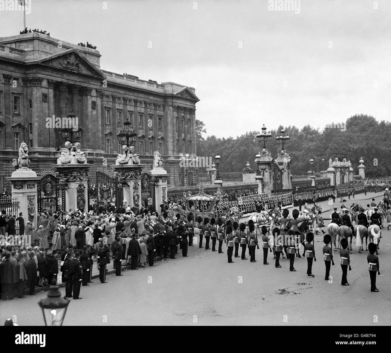 Le folle si acclamano mentre il Golden state Coach che porta la Regina e il Duca di Edimburgo lasciano Buckingham Palace in processione sulla strada per l'Abbazia di Westminster per la cerimonia dell'incoronazione. Foto Stock