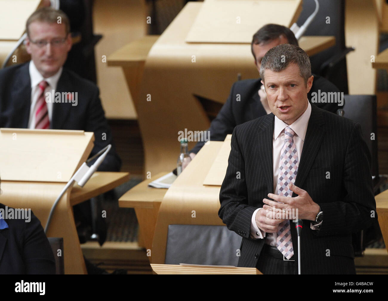 Il leader del partito liberale Willie Rennie parla durante il tempo delle interrogazioni al Parlamento scozzese di Edimburgo. Foto Stock